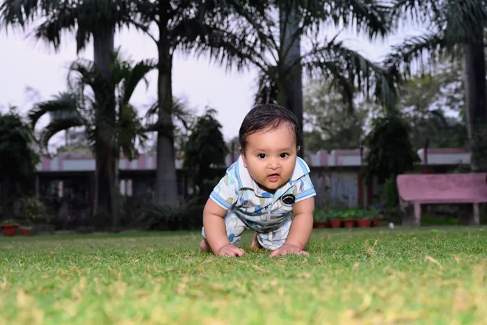Baby crawling on the grass during an outdoor session