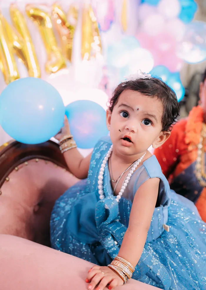 Toddler in a blue party dress at her birthday setup