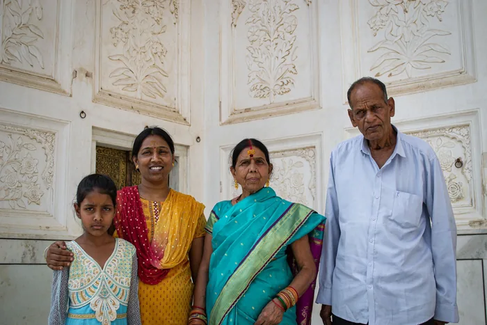 Three generations of a family photographed together at the door of their home
