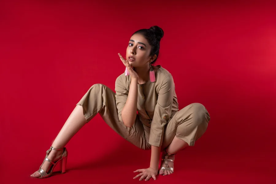 Model photographed against a red studio backdrop for a lookbook