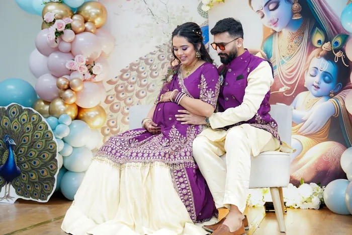 Expectant parents seated together at a decorated godh bharai setup