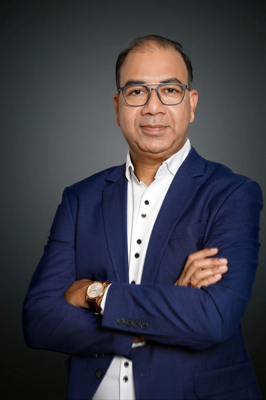 Professional headshot of a man in a blazer against a plain background