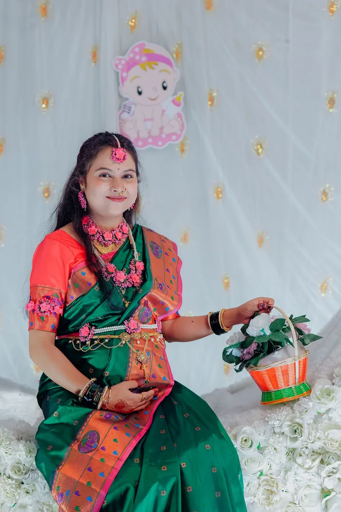 Expectant mother in a green traditional saree photographed at her ceremony