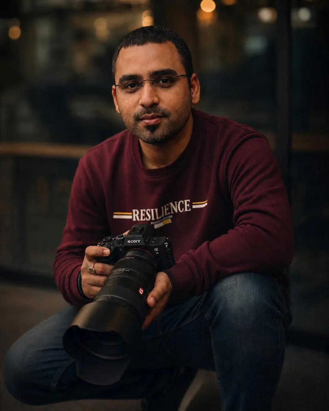Mohit Mishra, founder of Mohit Digitals, crouched with his camera