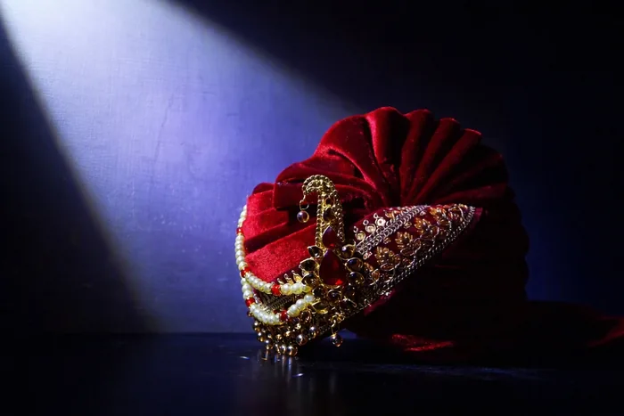A red safa photographed on a dark surface in a single beam of light