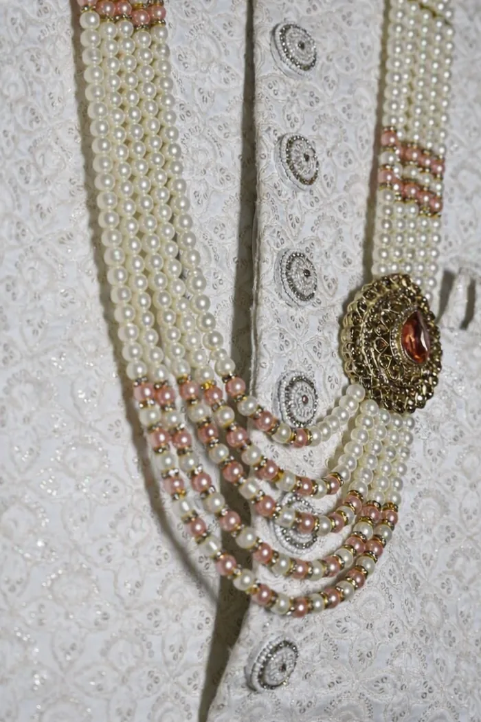 Close view of the groom's sherwani with the pearl mala and brooch