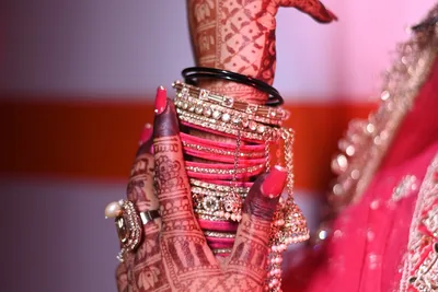 Close view of the bride's mehndi and chooda in warm, film-like colour